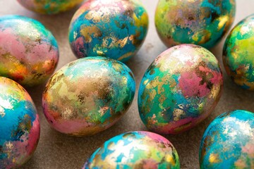 Colorful easter eggs background. Blue, yellow, pink, gold eggs. Selective focus.
