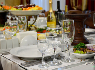 served festive table with empty glasses and plates. preparing for a festive evening in anticipation of guests and friends