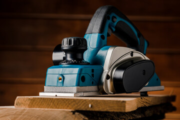 Manual electric plane on an untreated log of a tree. Wooden products. Production of wood products.