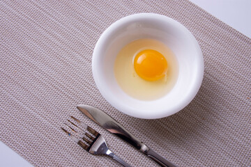 白い容器に割った生たまご