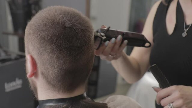 Hair cutting machine, beauty salon, hairdresser, man's head, nape, hair falling, close-up, side view