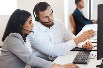 Try doing it like this next time. Shot of two call centre agents working together on a computer in an office.