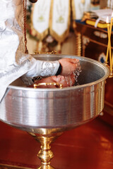 baptism of a child in the church. Ukrainian Orthodox Church. Orthodox baptism of a child. Church rite of acceptance of faith. The priest baptizes the baby