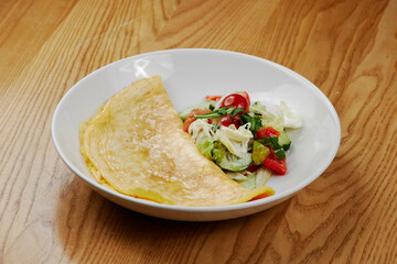 big omelet with vegetable salad
