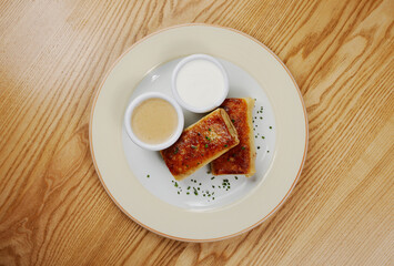 Pancakes with meat, with sauce and sour cream, decorated with herbs