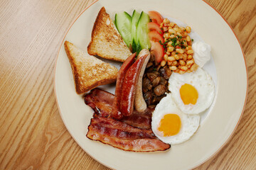 german breakfast of sausages, bacon, eggs and vegetables