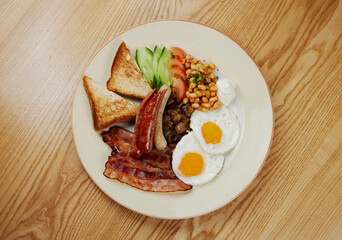 german breakfast of sausages, bacon, eggs and vegetables