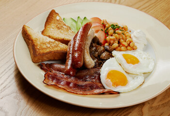 german breakfast of sausages, bacon, eggs and vegetables