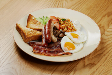 german breakfast of sausages, bacon, eggs and vegetables