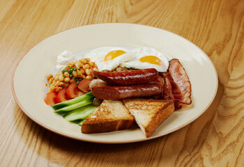 german breakfast of sausages, bacon, eggs and vegetables