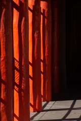 Obraz premium abstract design of of black shadows on vibrant orange wooden pillars shadows of fence cast on pillars in afternoon sunlight in down town Santa Fe New Mexico near plaza colorful vertical backdrop 