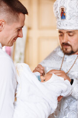 baptism of a child in the church. Ukrainian Orthodox Church. Orthodox baptism of a child. Church rite of acceptance of faith. The priest baptizes the baby - obrazy, fototapety, plakaty