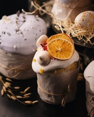 Easter cake decorated with icing, candied fruit, lavender and chocolate on a dark background with decoration