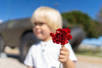 Kid holding red clove for 25 of April, celebration of 50 Years, Portugal freedom day. Revolution of...