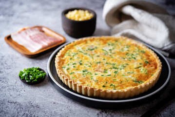 Bacon quiche with cheese and scallions in a plate