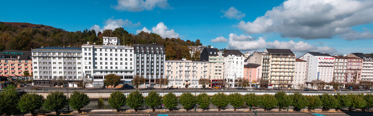 Fototapeta na wymiar Lourdes, France - October 26, 2021: Panoramic picture of hotels on the banks of the river Ousse in the pilgrimage site of Lourdes, France
