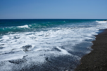 The wonderful turquoise waters of the famous Perissa beach in Santorini