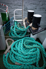 on the deck of a ship lie long ropes for mooring the ship