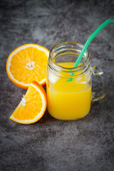 Obraz na płótnie Canvas A glass of orange juice on a dark background