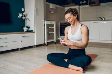 Woman using smartphone after training at home