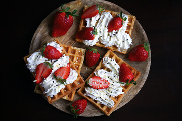 Obraz na płótnie Canvas Belgian waffles with strawberries and cream.