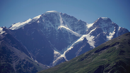 Beautiful high mountains with snow. CLIP. Blue mountains and white peaks. Diverse mountains with greenery and snow