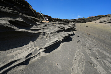 Layers of olivine crystals on the landslide above Papakolea Beach aka Green Sand Beach near South Point on Big Island, Hawaii, United states
