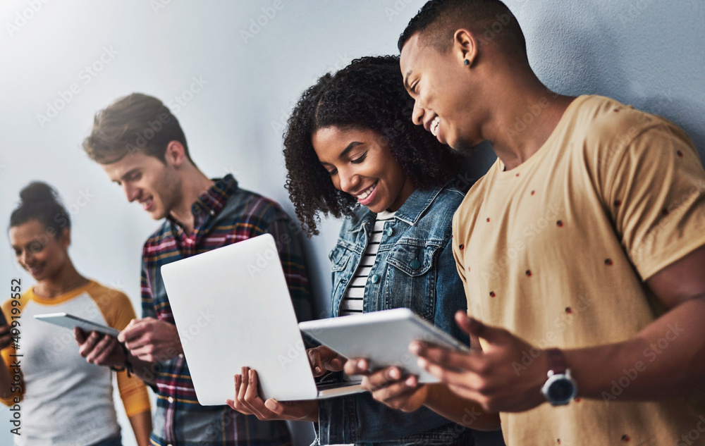 Wall mural keep sharing that connection. studio shot of a group of young people using wireless technology again