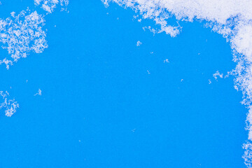 Blue background and grains of white snow.