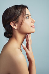 Give a girl the right skincare and shell rule. Sideview of a young woman with flawless skin against a grey background. - obrazy, fototapety, plakaty