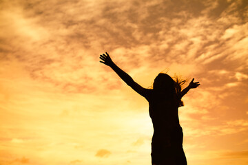 Fototapeta na wymiar Happy confident woman with arms up to the sky 