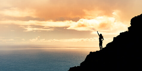 Achievement, goal setting and overcoming life obstacles concept. Victory on a mountain top. Woman...