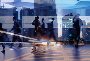 business people crowd walking commuting in the city, lights and motion blur abstract 