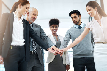 Obraz premium Success is even better when its shared. Shot of a diverse team of colleagues joining their hands together in solidarity.
