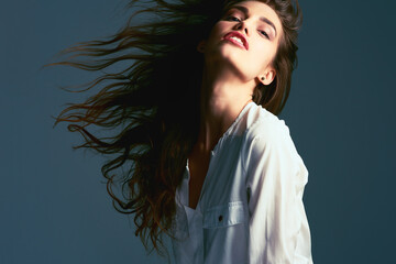 Whip your hair back and forth. Studio shot of an attractive young fashionable woman posing against...