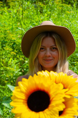 Girl in a white dress with sunflowers in the forest