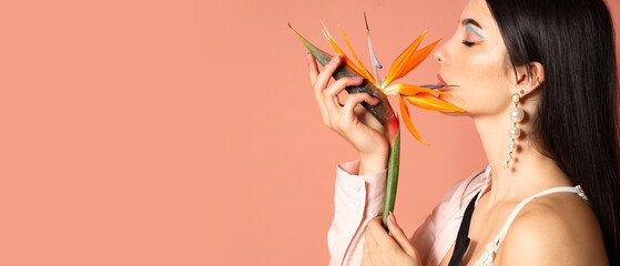 Beautiful young woman holding strelitzia flower on color background with space for text
