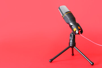 Stand with modern microphone on red background