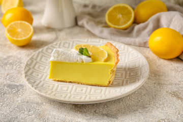 Plate with piece of tasty lemon pie and fresh fruits on light background