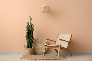 Big cactus with pouf and armchair near beige wall
