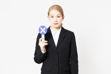 NGのプレートを見せる若い女性