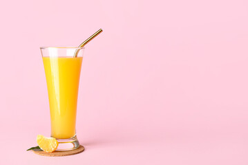 Glass of fresh tangerine juice on pink background