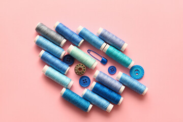 Different thread spools and buttons on color background