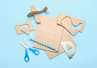 Materials for making cardboard plane toy on blue background