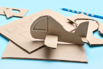 Cardboard plane on blue background, closeup
