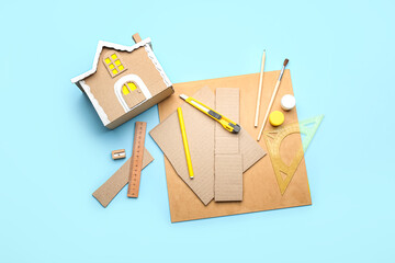 Materials for making cardboard house on blue background