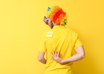 Funny man in disguise and with sticky note on his back against yellow background. April fools' day...