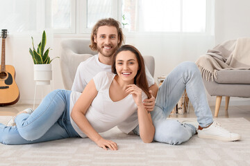 Fototapeta na wymiar Young couple on soft carpet at home