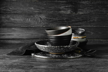 Set of stylish dinnerware on dark wooden background