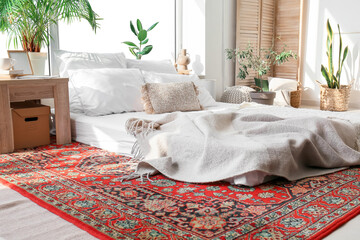 Interior of cozy bedroom with houseplants and vintage carpet